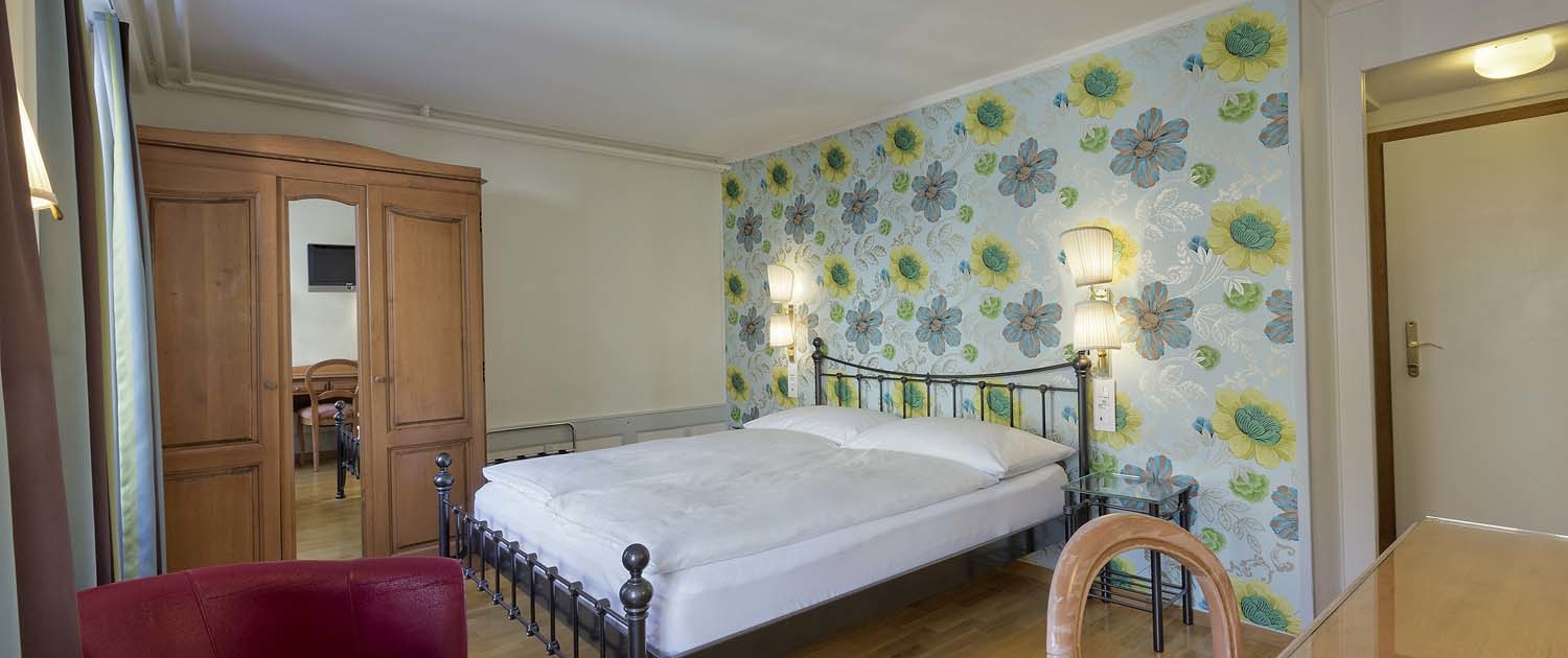 Beautiful double rooms with designer wallpaper and historic furniture at Alplodge Hotel in Interlaken Switzerland